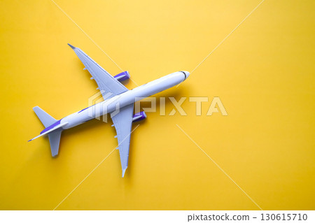 flat lay of airplane model on yellow background, travel and holidays concept 130615710