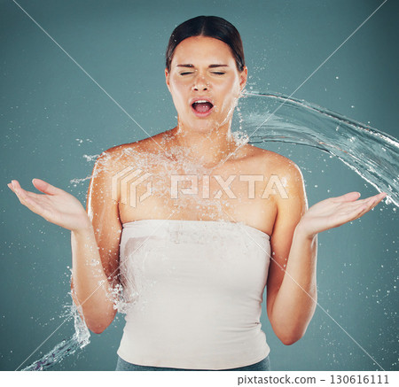 Cleaning, grooming and woman surprised with a water splash isolated on a blue background in a studio. Spa, shower and shocked girl with water for skincare, hydration and dermatology on a backdrop Cleaning, grooming and woman surprised with a water splash isolated on a blue background in a studio. Spa, shower and shocked girl with water for skincare, hydration and dermatology on a backdrop 130616111