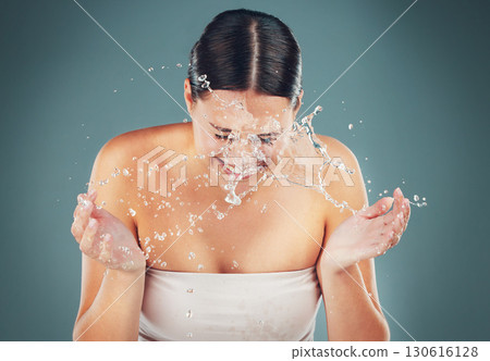 Beauty, water splash and washing face for skincare, cleaning and dermatology on a studio background. Health and wellness of a aesthetic model person cleaning skin or body for facial spa treatment Beauty, water splash and washing face for skincare, cleaning and dermatology on a studio background. Health and wellness of a aesthetic model person cleaning skin or body for facial spa treatment 130616128