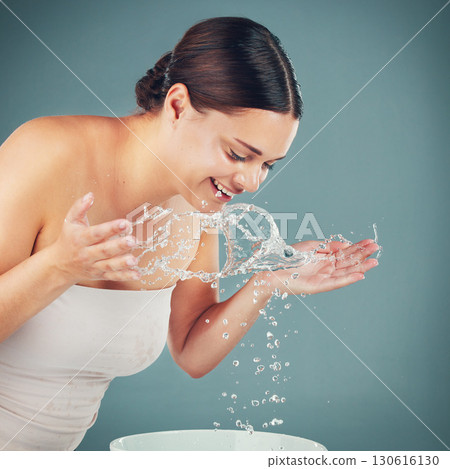 Water splash, woman and skincare while washing face for dermatology wellness on a studio background. Health and glow of a happy aesthetic model person cleaning skin or body for facial spa treatment Water splash, woman and skincare while washing face for dermatology wellness on a studio background. Health and glow of a happy aesthetic model person cleaning skin or body for facial spa treatment 130616130