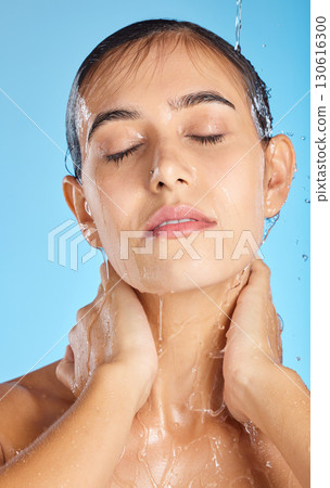Woman, shower water and face of a calm model ready for morning skincare and wellness. Blue background, studio and isolated female relax with peace from facial beauty cleaning and self care alone 130616300