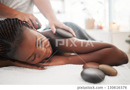 Black woman, hot stone massage, spa with hands of masseuse, holistic and wellness with treatment. Health, peace of mind and zen, self care and rocks, stress relief for people and back skin detox Black woman, hot stone massage, spa with hands of masseuse, holistic and wellness with treatment. Health, peace of mind and zen, self care and rocks, stress relief for people and back skin detox 130616376