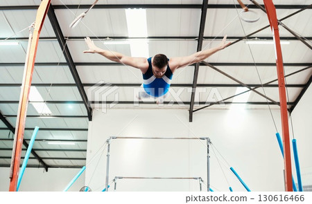 Man, acrobat and gymnast flying off rings in fitness for practice, training or workout at gym. Professional male in gymnastics or performance for athletics, acrobatic or strength and balance exercise 130616466