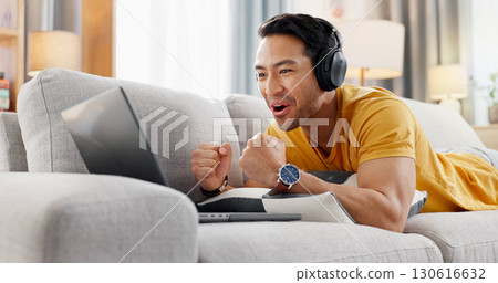 Man, laptop and headphones on sofa for sport, social media and video streaming or website in home. Excited, cheer and male person on couch with technology, break and watching tournament on app Man, laptop and headphones on sofa for sport, social media and video streaming or website in home. Excited, cheer and male person on couch with technology, break and watching tournament on app 130616632