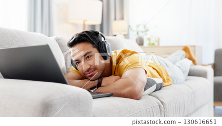 Man, laptop and headphones on sofa for break, social media and video streaming or website in home. Movie, internet audio and male person on couch with technology, relax and watching film on app Man, laptop and headphones on sofa for break, social media and video streaming or website in home. Movie, internet audio and male person on couch with technology, relax and watching film on app 130616651