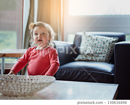 Children, baby and a girl in the living room of her home with mockup or flare looking curious while standing alone. Kids, development and lifestyle with a cute female child in a house during the day Children, baby and a girl in the living room of her home with mockup or flare looking curious while standing alone. Kids, development and lifestyle with a cute female child in a house during the day 130616898