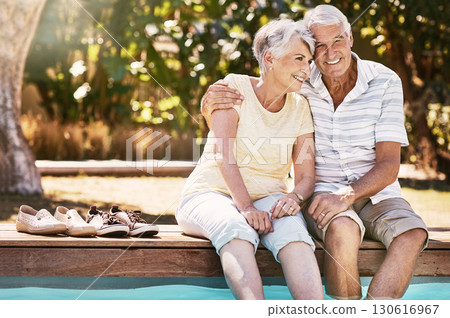 Senior couple, hug and swimming pool for summer vacation, love or relax spending quality bonding time together. Happy elderly man holding woman relaxing with feet in water by the poolside outside 130616967