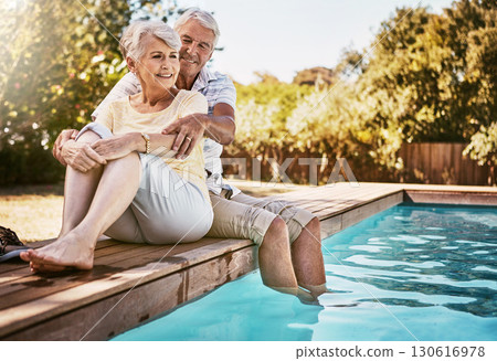 Senior couple, hug and relax by pool for love and summer vacation, bonding or quality time together in the outdoors. Happy elderly man and woman relaxing and hugging with feet in water by a poolside Senior couple, hug and relax by pool for love and summer vacation, bonding or quality time together in the outdoors. Happy elderly man and woman relaxing and hugging with feet in water by a poolside 130616978