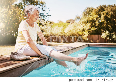 Relax, travel and senior woman by the pool while on a vacation, adventure or outdoor trip in summer. Happy, smile and elderly lady in retirement with her feet in the swimming pool at a holiday resort 130616986