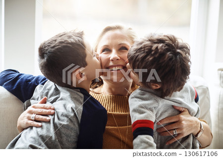 Kiss, bonding and a mother with children for love, relax and playing in a family home together. Hug, smile and mom with affection for boy kids during quality time on the living room sofa of a house 130617106