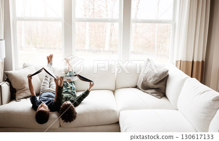 Fun kids, bonding and reading books in education, learning or relax studying upside down on house living room or sofa. Children, storytelling and fantasy fairytale novel in creative home inspiration 130617133