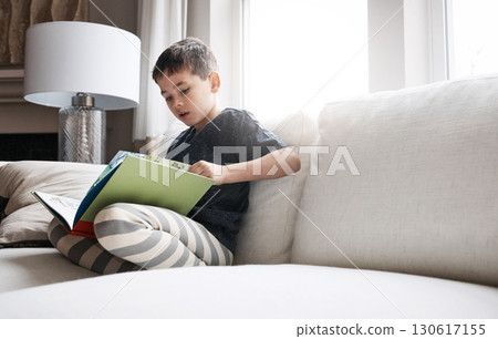 Child, boy or reading book for education, learning and relax studying on house living room or family home sofa. Kid, storytelling or fantasy fairytale novel for hobby activity or creative inspiration Child, boy or reading book for education, learning and relax studying on house living room or family home sofa. Kid, storytelling or fantasy fairytale novel for hobby activity or creative inspiration 130617155