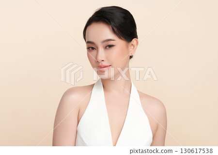 A beautiful young Asian woman with clean, fresh skin against a beige background. Skincare, facial treatment, cosmetology, beauty, and spa. An elegant portrait of an Asian woman. A beautiful young Asian woman with clean, fresh skin against a beige background. Skincare, facial treatment, cosmetology, beauty, and spa. An elegant portrait of an Asian woman. 130617538