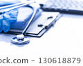 Healthcare medical background with copy-space of stethoscope clipboard, folded overalls, gloves and computer keyboard on white table 130618879