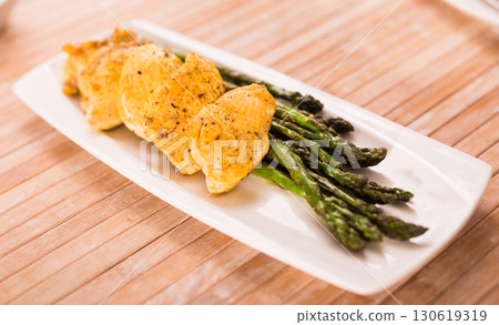 cooked dish. Chicken nuggets with green asparagus on plate cooked dish. Chicken nuggets with green asparagus on plate 130619319