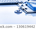 Healthcare medical background with copy-space of stethoscope clipboard, folded overalls and computer keyboard on white table 130619442