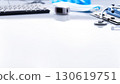 Healthcare background of stethoscope, pulse oximeter, clipboard, folded overalls, gloves and computer keyboard on white table with copy-space 130619751
