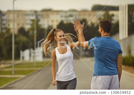 Woman Giving High Five to Male Coach During City Park Workout Woman Giving High Five to Male Coach During City Park Workout 130619952