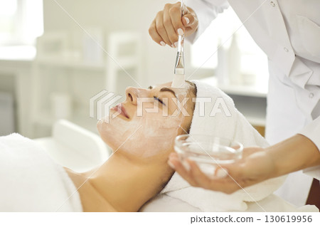 Young woman enjoying professional skin care done by beautician at spa and beauty salon 130619956