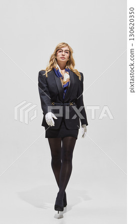 Woman walking confidently in black blazer with scarf and gloves Woman walking confidently in black blazer with scarf and gloves 130620350