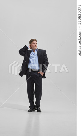 Businessman in open jacket posing with confidence and relaxed energy Businessman in open jacket posing with confidence and relaxed energy 130620375