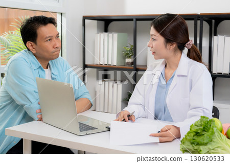 Asian nutritionist consulting patient in clinic, meal plan discussion, healthcare advice. 130620533