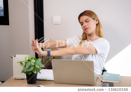 Portrait young caucasian businesswoman taking a break after overworked with stretching arm. 130620589