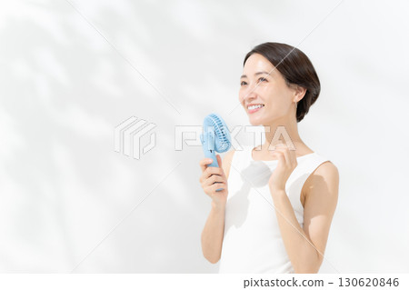 A woman who cools down with a handy fan 130620846