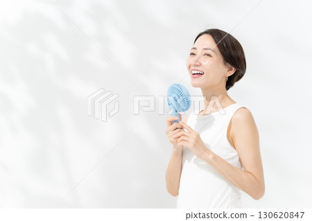 A woman who cools down with a handy fan A woman who cools down with a handy fan 130620847