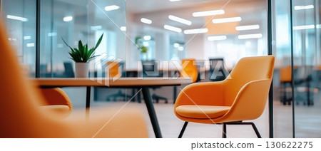 modern office interior featuring stylish orange chairs and sleek table, creating vibrant and inviting workspace 130622275