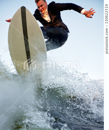 Businessperson surfing on waves for a dynamic and creative lifestyle representation 130622519