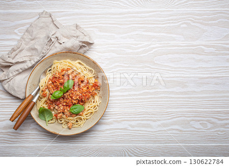 Spaghetti bolognese with basil garnish on white wooden table 130622784