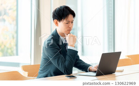 A male businessman worried while using a computer 130622969