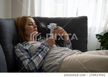 Nebuliser aerosol. Middle age woman with inhaler machine, seasonal flu Nebuliser aerosol. Middle age woman with inhaler machine, seasonal flu 130623091
