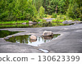 Scenic forest with rocks, water and lush greenery in tranquil natural setting, landscape of Karelia, Russia 130623399