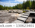 Scenic wooden pathway through rocky terrain and dense forest in Zalavruga, area with prehistoric art in Karelia, Russia 130623401