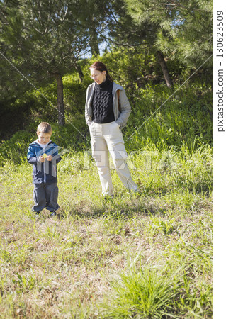 Mother and son enjoying nature walk in sunny forest Mother and son enjoying nature walk in sunny forest 130623509
