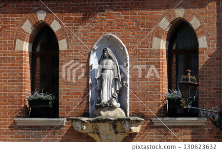 Virgin Mary statue on the facade of palace on the Piazza Duomo in Verona, Italy 130623632
