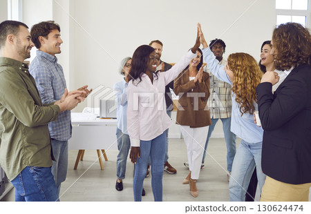 Happy colleagues giving high five at meeting at office, celebrating success or business achievement 130624474