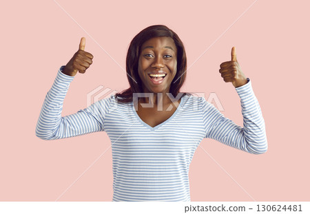 Young happy african american woman showing thumb up like gesture isolated on pink background. Young happy african american woman showing thumb up like gesture isolated on pink background. 130624481