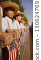 Close-up young children in white shirts suspenders cowboy hats holding American flags along fence cinematic Hasselblad photography high realism ultra-realistic patriotic parade stock photo 130624769