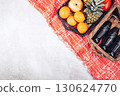 Picnic basket with fruit and wine bottles on orange plaid blanket concrete background top view minimalistic stock photo free space for text perfect for summer food lifestyle or advertisement 130624770