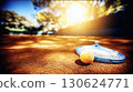 Tennis racket and ball lying on outdoor court on sunny day with blurred background. Professional sports concept with bright colors natural light and shallow depth for design or poster 130624771