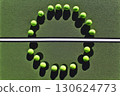 Flat lay of tennis balls arranged in circle on green hard court surface with white line crossing. Sports background for design concept tournament training or fitness wellness promotion 130624773