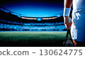 Close up of athlete hands gripping tennis racket with dramatic light and blurred stadium. Powerful sport background concept for training competition poster or motivational promotion 130624775