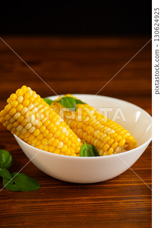 fresh corn on a wooden background with greenery 130624925