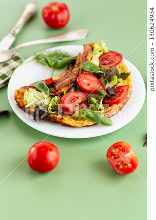 Golden omelette with salad mix and spicy aroma on top Golden omelette with salad mix and spicy aroma on top 130624934