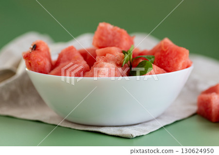 bowl with watermelon pieces and mint leaves nearby bowl with watermelon pieces and mint leaves nearby 130624950