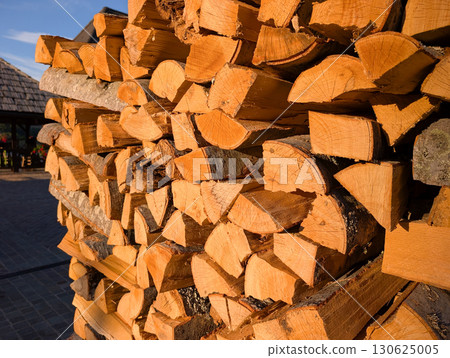Stack of freshly cut firewood in sunlight. Rustic lifestyle and winter preparation in Serbian village. Stack of freshly cut firewood in sunlight. Rustic lifestyle and winter preparation in Serbian village. 130625005