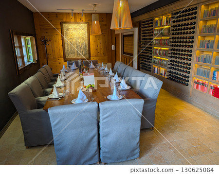 Reserved rustic dining table with portrait on wall. Heritage, tradition, hospitality and cultural dining environment. Reserved rustic dining table with portrait on wall. Heritage, tradition, hospitality and cultural dining environment. 130625084